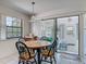 Charming breakfast nook features a round wooden table, sliding glass doors to lanai, and natural light from large window at 907 Silver Leaf Pl, Port Orange, FL 32127