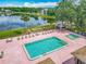 A stunning aerial view of the community pool and spa, surrounded by lounge chairs, with a tranquil lake as a backdrop at 907 Silver Leaf Pl, Port Orange, FL 32127