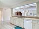 Bright kitchen featuring white cabinets and a pass-through window to the dining room at 907 Silver Leaf Pl, Port Orange, FL 32127