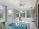 Bright sunroom with large windows, ceiling fan, and tile flooring at 907 Silver Leaf Pl, Port Orange, FL 32127