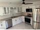 Well-equipped kitchen with white cabinetry, marble floors, and stainless steel appliances at 908 Boulder Dr, South Daytona, FL 32119