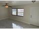 Bright living room with ceiling fan, white walls, new marble floors and large windows at 908 Boulder Dr, South Daytona, FL 32119