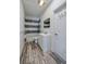 Bathroom featuring gray and white tiled shower, white vanity, modern fixtures, and wood-look floors at 940 Valencia Ave, Daytona Beach, FL 32114