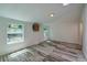 Bright bedroom with wood-look flooring, white walls, and multiple windows overlooking greenery at 940 Valencia Ave, Daytona Beach, FL 32114