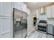Kitchen featuring stainless steel refrigerator, range, hood, and white cabinets with wood-look flooring at 940 Valencia Ave, Daytona Beach, FL 32114