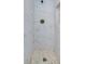 Modern shower with white marble-look tile, pebble floor, and bronze shower head at 940 Valencia Ave, Daytona Beach, FL 32114