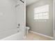 Bathroom with tub and shower, white tile surround, and window for natural light at 941 Pizarro Dr, Daytona Beach, FL 32119