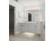 Bathroom with white cabinetry, double sinks and ample counter space with light tile flooring at 941 Pizarro Dr, Daytona Beach, FL 32119