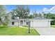 Charming single-story home boasts a manicured lawn, mature trees, and an attached two-car garage at 941 Pizarro Dr, Daytona Beach, FL 32119