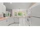 Bright kitchen features white appliances, cabinetry and breakfast nook with natural light at 941 Pizarro Dr, Daytona Beach, FL 32119