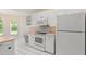 Bright kitchen offers white appliances, cabinetry and tile flooring, with natural light at 941 Pizarro Dr, Daytona Beach, FL 32119