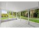 Enclosed lanai with tile flooring provides a view of the manicured backyard at 941 Pizarro Dr, Daytona Beach, FL 32119