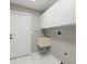 Bright laundry room features white cabinets, neutral walls and tiled floors at 941 Pizarro Dr, Daytona Beach, FL 32119