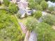 Aerial view of house with solar panels, mature landscaping, and a nearby pond at 1018 Heron Point Cir, Deland, FL 32724