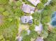 Aerial view showcasing the home's location, surrounded by lush greenery, a lake, and neighboring houses at 1018 Heron Point Cir, Deland, FL 32724
