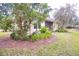 Backyard featuring mature landscaping, mulch beds, and lush green grass at 1018 Heron Point Cir, Deland, FL 32724