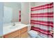 Modest bathroom featuring sink, toilet, and shower with striped curtain for added privacy at 1018 Heron Point Cir, Deland, FL 32724