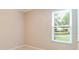 Bright bedroom with tile flooring, base trim, and a window with natural light and neighborhood views at 1018 Heron Point Cir, Deland, FL 32724
