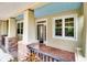 Close up of a charming front porch with stone pillars, a decorative railing, and a glass-paneled door at 1018 Heron Point Cir, Deland, FL 32724