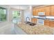 Open kitchen with granite island, stainless sink, and wooden cabinets at 1018 Heron Point Cir, Deland, FL 32724