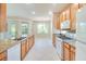 Well-lit kitchen features wooden cabinets, granite countertops, and white appliances at 1018 Heron Point Cir, Deland, FL 32724