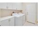 Laundry room featuring a washer, dryer, overhead cabinets, and access door at 1018 Heron Point Cir, Deland, FL 32724