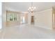 Bright, expansive living room with tile flooring, shuttered windows, and an elegant chandelier at 1018 Heron Point Cir, Deland, FL 32724