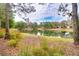 Tranquil view of a pond reflecting the sky and surrounding trees, enhancing the community's serene atmosphere at 1018 Heron Point Cir, Deland, FL 32724