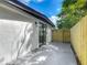 A concrete back patio with a sliding glass door and a newly constructed wooden fence at 102 Judges Ln, Port Orange, FL 32129