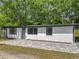 Charming white single-story house featuring a gray door, black trim, and brick pathway at 102 Judges Ln, Port Orange, FL 32129