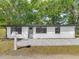 Charming single-story home features a crisp white exterior, gray door, and brick walkway at 102 Judges Ln, Port Orange, FL 32129