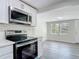 Updated kitchen with modern stainless steel range and microwave, and eat in kitchen area at 102 Judges Ln, Port Orange, FL 32129