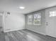 Bright living room featuring wood-look floors, fresh gray paint, and natural light from two windows at 102 Judges Ln, Port Orange, FL 32129