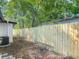 View of the side yard with a newly constructed wooden fence and some shade at 102 Judges Ln, Port Orange, FL 32129
