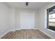 Bedroom featuring wood-look floors, a closet with double doors, and a large window at 104 Balmoral Ct, Debary, FL 32713