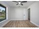 Light-filled bedroom with wood-look floors and a door to another area of the home at 104 Balmoral Ct, Debary, FL 32713