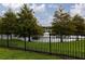 Backyard view of the lake framed by trees and a wrought iron fence at 1118 Avery Meadows Way, Deland, FL 32724