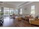 Open-concept living room with wood floors, large windows, and a view of the screened-in lanai at 1118 Avery Meadows Way, Deland, FL 32724