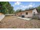 Backyard featuring mature trees, block wall, concrete patio, and a home with chimney at 1209 James Ter, Daytona Beach, FL 32117