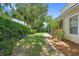 Secluded backyard with green lawn, mature trees, and brick-lined garden, offering a peaceful and private outdoor space at 123 Ivydale Manor Dr, Deland, FL 32724