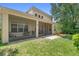 Spacious backyard features a screened lanai, lush lawn, and mature trees, perfect for outdoor living and entertaining at 123 Ivydale Manor Dr, Deland, FL 32724