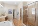 Bright bathroom featuring a glass shower, soaking tub, and double doors at 123 Ivydale Manor Dr, Deland, FL 32724