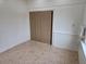 Well-lit bonus room featuring neutral walls, tile floors, and closet with sliding doors at 1408 W Wellington Dr, Deltona, FL 32725