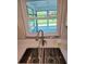 Close-up of a stainless steel kitchen sink with granite countertops and window views at 1408 W Wellington Dr, Deltona, FL 32725