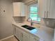 Modern kitchen sink with white cabinets, granite countertops and a window at 1408 W Wellington Dr, Deltona, FL 32725