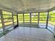Bright sunroom featuring tiled floors, ceiling fan, and large windows showcasing the outdoor greenery at 1408 W Wellington Dr, Deltona, FL 32725
