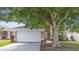 Beige home exterior with a two car garage and green landscaping at 14634 Brightwell Ct, Orlando, FL 32824