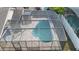 An aerial shot of a screened pool and patio area next to a white fence and home at 14634 Brightwell Ct, Orlando, FL 32824