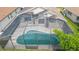 Aerial view of a screened in pool with attached spa on a home with a tan exterior at 14634 Brightwell Ct, Orlando, FL 32824