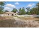 Large backyard with privacy fence, patio, shed, and lush trees, offering ample space for recreation at 149 Angeles Rd, Debary, FL 32713
